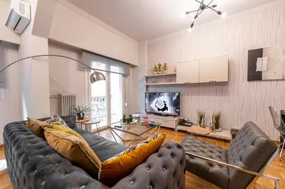 a living room with a couch and a tv at Alopece City Apartment - Kolonaki in Athens