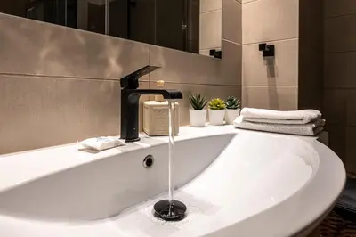 a sink in a bathroom with a faucet at Alopece City Apartment - Kolonaki in Athens