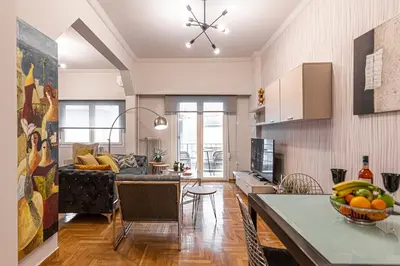 a kitchen and living room with a couch and a table at Alopece City Apartment - Kolonaki in Athens