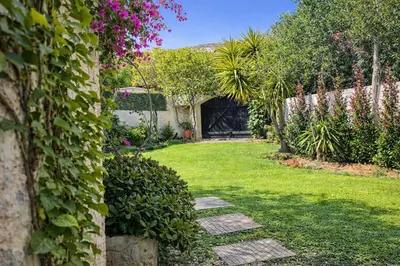 a garden with green grass and pink flowers at Villa Xenia&Akis in Athens