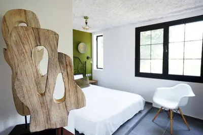 a bedroom with a white bed and a chair at Villa Xenia&Akis in Athens