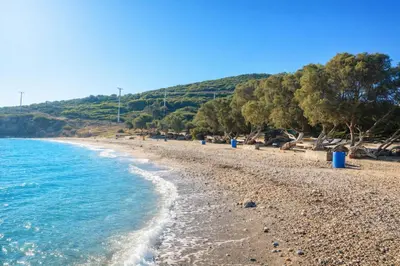 a beach with blue trash cans on the shore at Villa Xenia&Akis in Athens