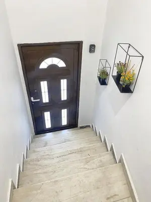 a hallway with a wooden door and stairs with plants at Check Point - Museum in Athens