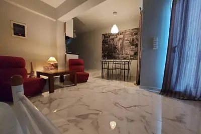 a living room with a marble floor and red chairs at Urban Downtown Studio Back in Athens
