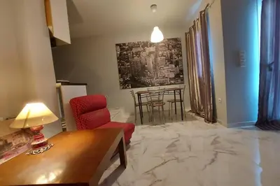 a living room with a red chair and a table at Urban Downtown Studio Back in Athens