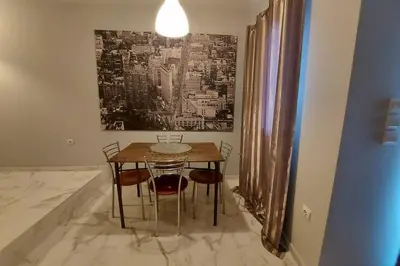 a dining room table with chairs and a painting on the wall at Urban Downtown Studio Back in Athens