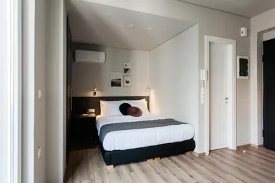 a man laying on a bed in a bedroom at WYZ Athens Apartments by UPSTREET in Athens