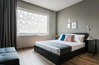 a bedroom with a bed and a large window at WYZ Athens Apartments by UPSTREET in Athens