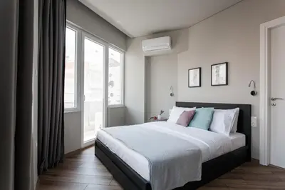 a bedroom with a bed and a large window at WYZ Athens Apartments by UPSTREET in Athens