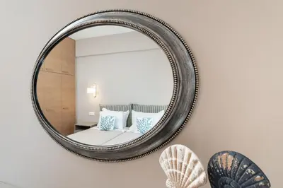 a mirror on a wall with a bed and pillows at Absolute Athens XII in Athens