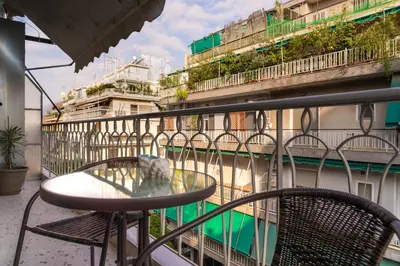 a table and chairs on a balcony with a building at Absolute Athens XII in Athens