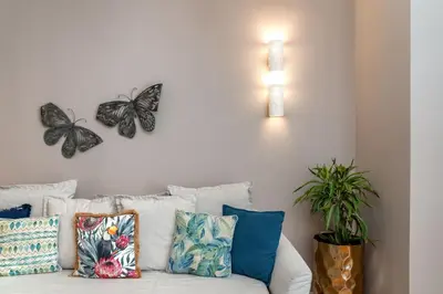 a white couch with butterflies on the wall at Absolute Athens XII in Athens