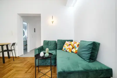 a green couch in a living room with a table at Majestic Flat with Huge Terrace in the City Center in Athens
