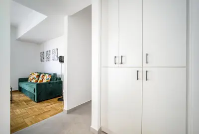 a living room with white cabinets and a green couch at Majestic Flat with Huge Terrace in the City Center in Athens