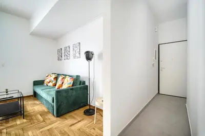 a living room with a green couch and a mirror at Majestic Flat with Huge Terrace in the City Center in Athens