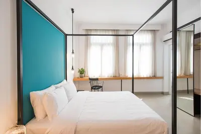 a bedroom with a large white bed and a table at MONK Monastiraki Suites in Athens