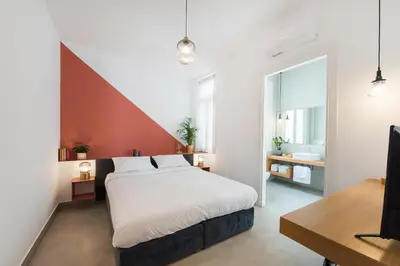 a bedroom with a large bed and a bathroom at MONK Monastiraki Suites in Athens