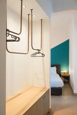 a bedroom with a bed and two chandeliers at MONK Monastiraki Suites in Athens