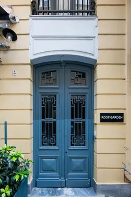 a blue door on a building with a balcony at MONK Monastiraki Suites in Athens