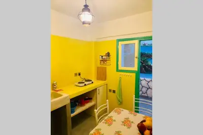 a kitchen with yellow walls and a table and a sink at Villa Kunterbunt in Athens