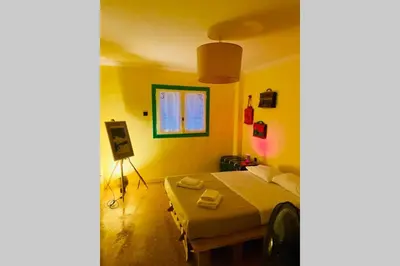 a bedroom with a bed in a room with yellow walls at Villa Kunterbunt in Athens