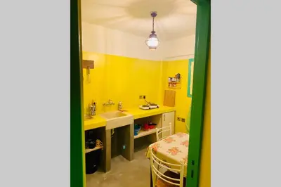 a bathroom with yellow walls and a sink and a table at Villa Kunterbunt in Athens