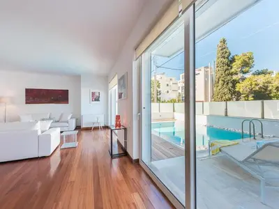 a living room with a white couch and a pool at Welcome to Lumen Villa the first of the Adelos Trilogy in Athens