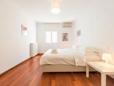 a white bedroom with a large bed and a table at Welcome to Lumen Villa the first of the Adelos Trilogy in Athens
