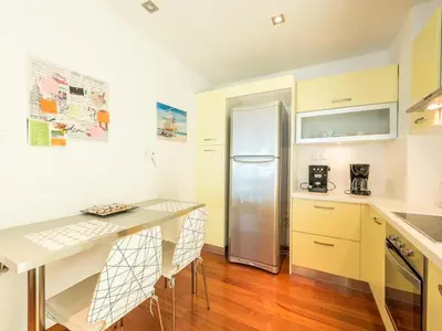 a kitchen with a refrigerator and a table with chairs at Adelos Coastal Chic by the Sea - Athens Riviera in Athens