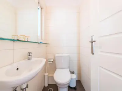 a white bathroom with a toilet and a sink at Adelos Coastal Chic by the Sea - Athens Riviera in Athens