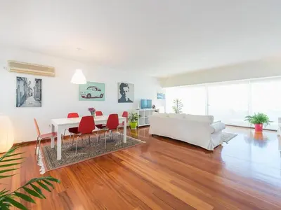 a living room with a white couch and a table and chairs at Adelos Coastal Chic by the Sea - Athens Riviera in Athens