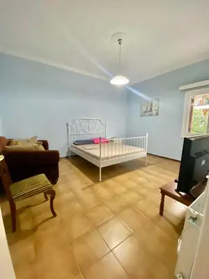 a living room with a crib and a couch at Tiffany's 5' min from airport in Spáta