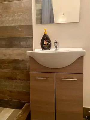 a bathroom with a white sink and a mirror at Tiffany's 5' min from airport in Spáta