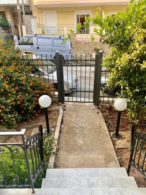 a black gate with two benches in front of a house at Tiffany's 5' min from airport in Spáta