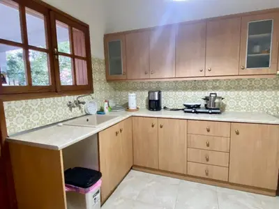 a kitchen with wooden cabinets and a counter top at Tiffany's 5' min from airport in Spáta
