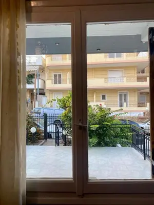 a door to a balcony with a view of a building at Tiffany's 5' min from airport in Spáta