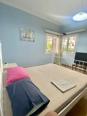 a bed in a room with a purple pillow at Tiffany's 5' min from airport in Spáta