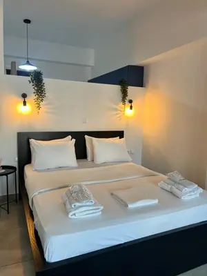 a bedroom with a bed with towels on it at Ælis Suites in Psyrri - Rooftop Access & Acropolis View in Athens