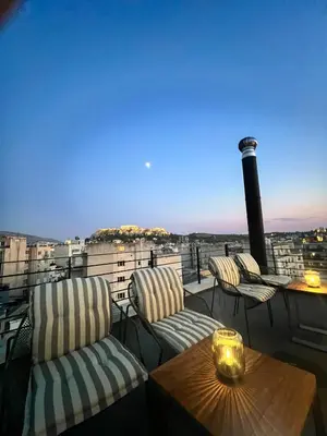 a balcony with chairs and a table with a view at Ælis Suites in Psyrri - Rooftop Access & Acropolis View in Athens