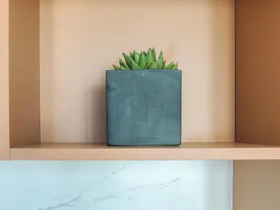 a green pot sitting on a shelf with a plant at Ælis Suites in Psyrri - Rooftop Access & Acropolis View in Athens