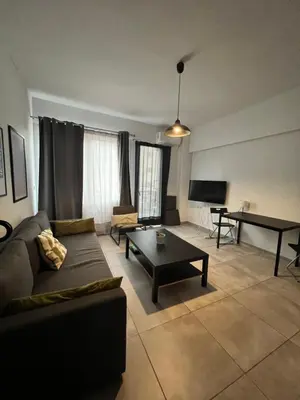 a living room with a couch and a table at Ælis Suites in Psyrri - Rooftop Access & Acropolis View in Athens