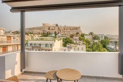 a room with a large window with two chairs and a table at Cozy Deck Roof Apt at the Foothills of Acropolis in Athens