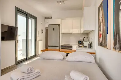 a white kitchen with two beds in a room at Cozy Deck Roof Apt at the Foothills of Acropolis in Athens