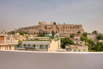 a view of a city with a hill in the background at Cozy Deck Roof Apt at the Foothills of Acropolis in Athens