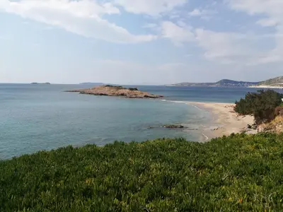 a beach with a small island in the water at Studio Agia Marina Koropi in Aghia Marina