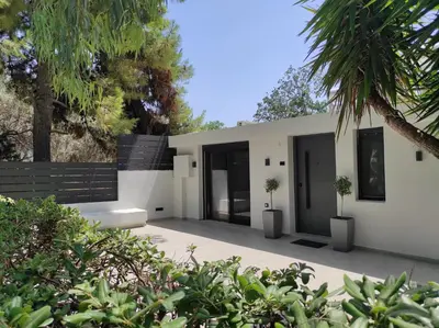a white house with two potted trees in front of it at Kavouri Seaside Luxury Bungalow in Athens