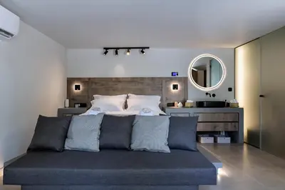 a bedroom with a bed and a mirror at Kavouri Seaside Luxury Bungalow in Athens