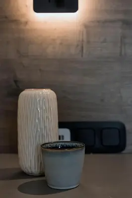 a white vase sitting next to a cup on a table at Kavouri Seaside Luxury Bungalow in Athens