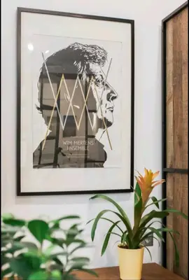 a framed picture of a man on a wall with a plant at Fashionable Base in Central Athens in the Old Tailor Factory in Athens