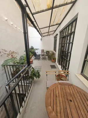 a balcony with a wooden table and chairs at Fashionable Base in Central Athens in the Old Tailor Factory in Athens